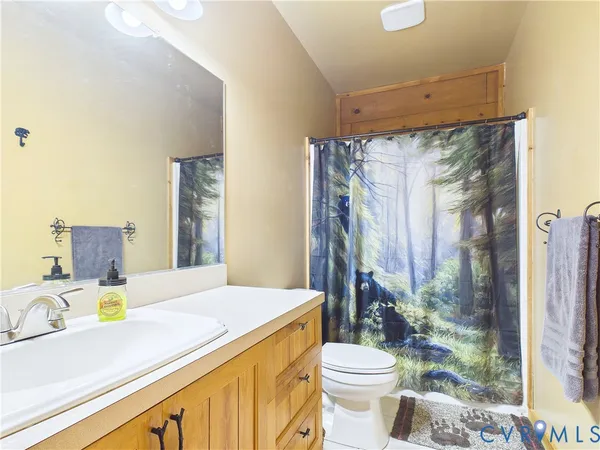 a bathroom with a granite countertop sink mirror vanity and toilet