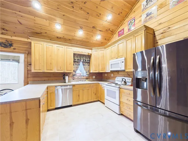 a kitchen with stainless steel appliances granite countertop a refrigerator a stove a sink dishwasher and a refrigerator
