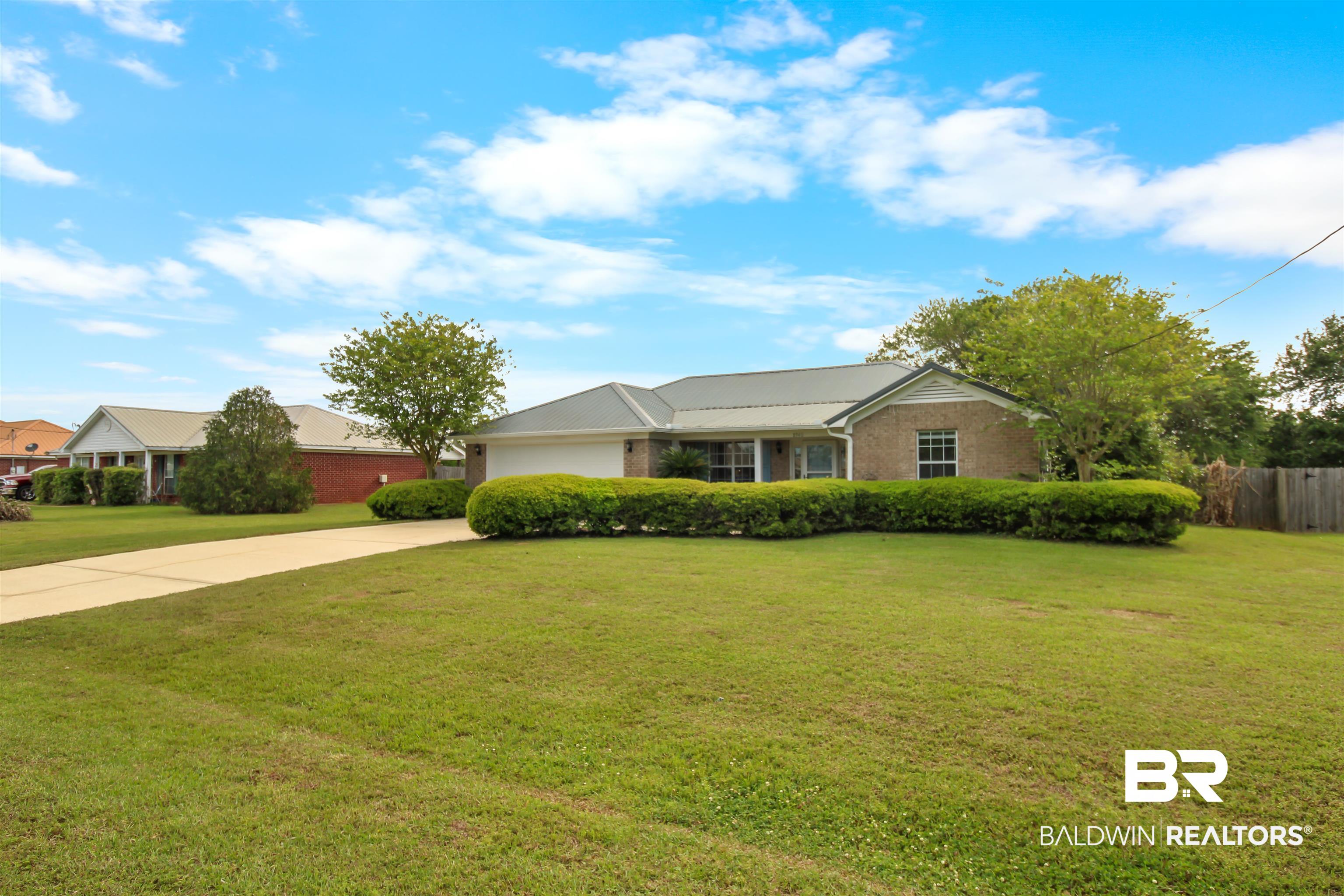 8940 Caitlin Street Foley, AL 36535 - Photo 21 of 27 Ranch-style house featuring driveway, an attached garage, and a metal roof