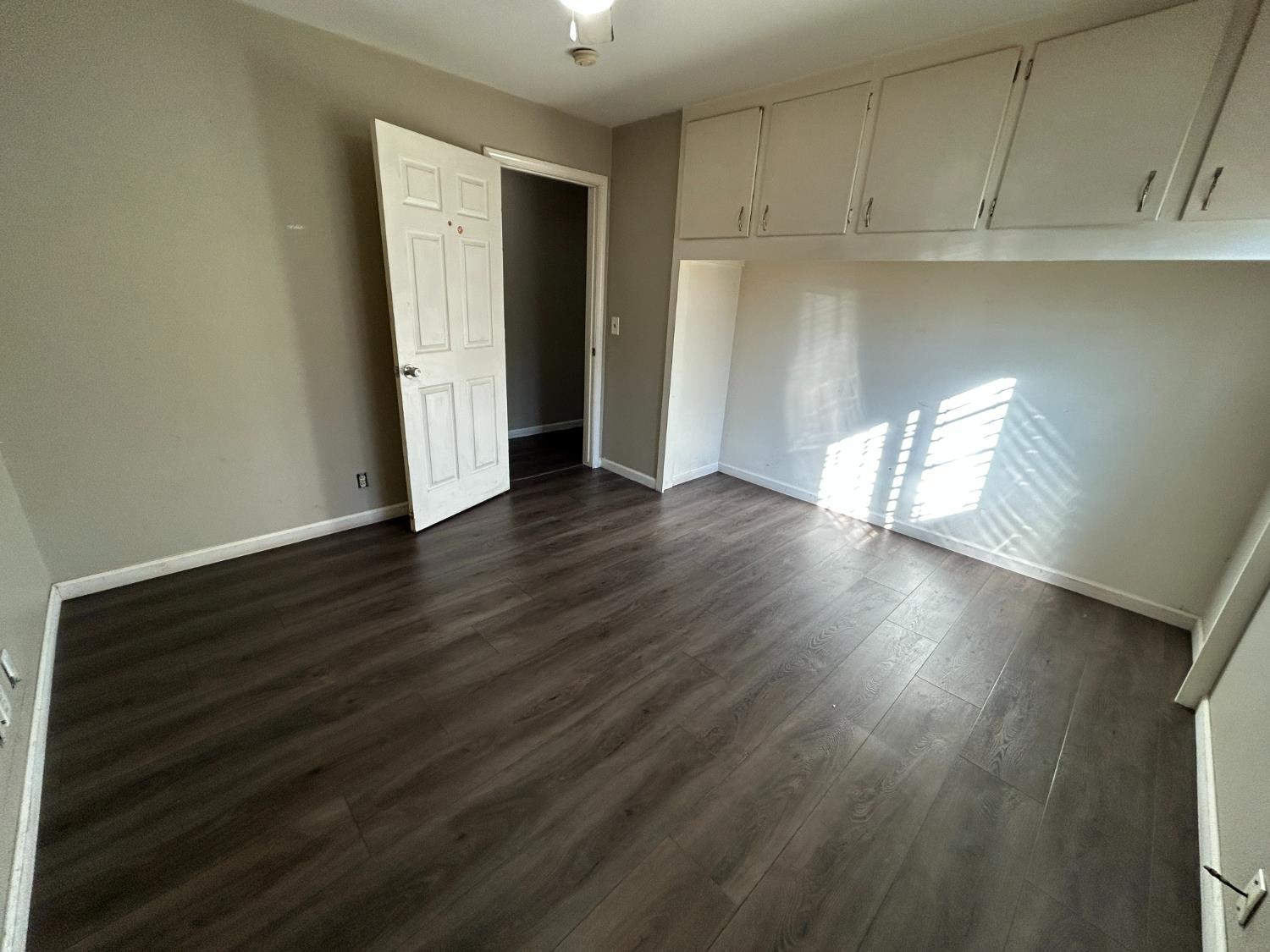 2581 Ballantyne Drive Merced, CA 95341 - Photo 8 of 16 an empty room with wooden floor and windows