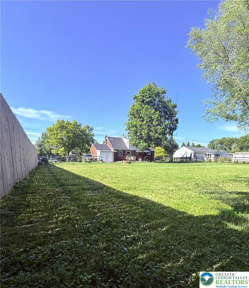 1275 Macada Road Bethlehem, PA 18017 - Photo 5 of 87 Enjoy the expansive backyard with a partial privacy fence and an open lawn leading to a charming house.