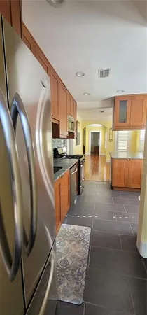 a kitchen with stainless steel appliances granite countertop a refrigerator stove and sink