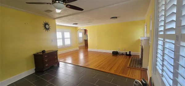 a view of a livingroom with wooden floor and a ceiling fan