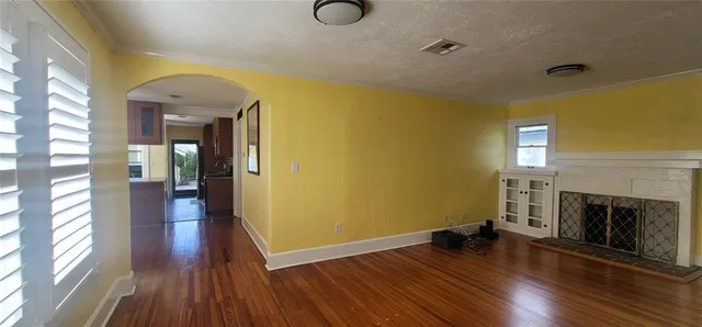 a view of a livingroom with wooden floor and a fireplace