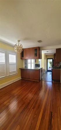 a living room with hard wood floors and a kitchen