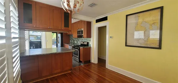 a view of a kitchen with a refrigerator cabinets and a wooden floor