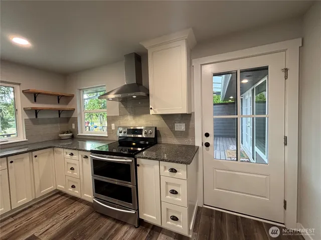 a kitchen with granite countertop white cabinets and white appliances