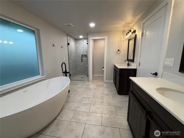 a bathroom with a tub sink and mirror