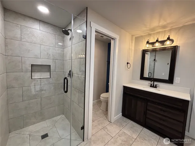 a bathroom with a double vanity sink toilet and shower
