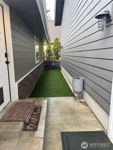 a view of backyard with a chair and potted plants