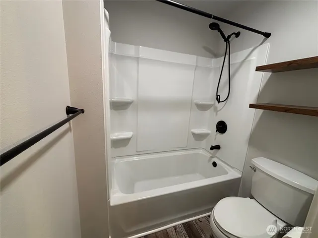 a white toilet and tub sitting next to a bathroom sink