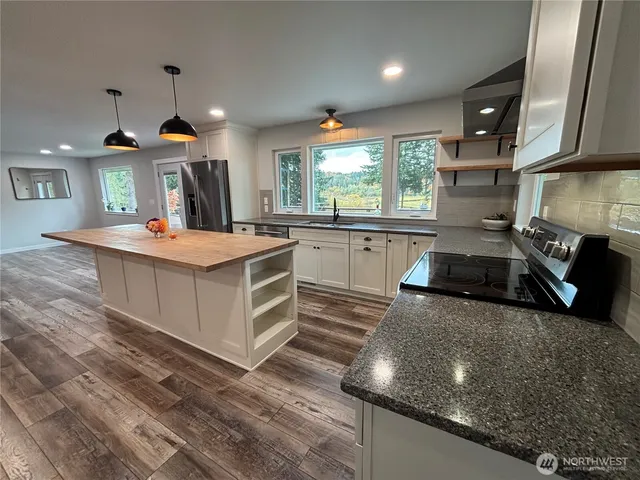 a kitchen with stainless steel appliances granite countertop a sink stove and refrigerator