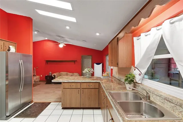 a kitchen with stainless steel appliances granite countertop a sink and a refrigerator