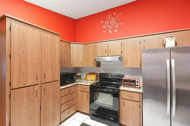 a kitchen with appliances a refrigerator and cabinets