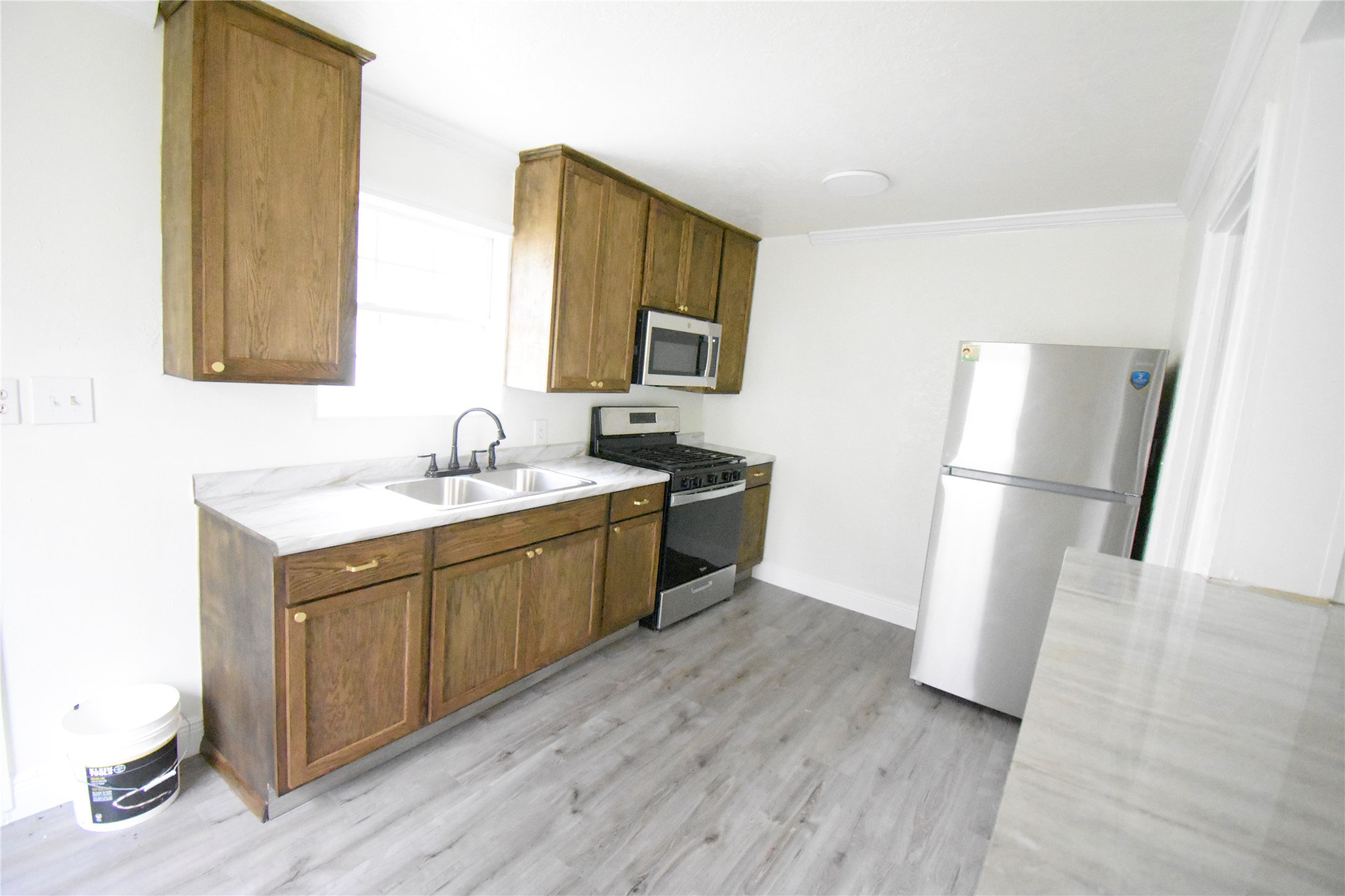 6229 Clover Ridge Street Houston, TX 77087 - Photo 15 of 25 a kitchen with sink refrigerator and microwave