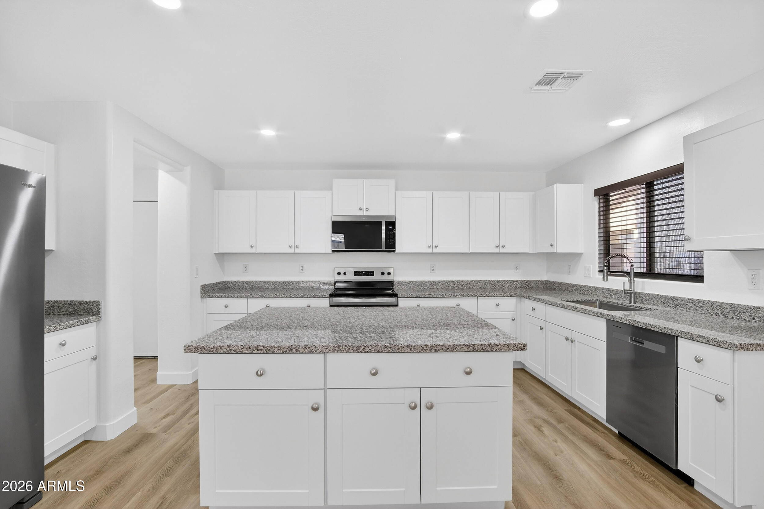 43620 West Cowpath Road Maricopa, AZ 85138 - Photo 17 of 60 a kitchen with granite countertop white cabinets and white appliances