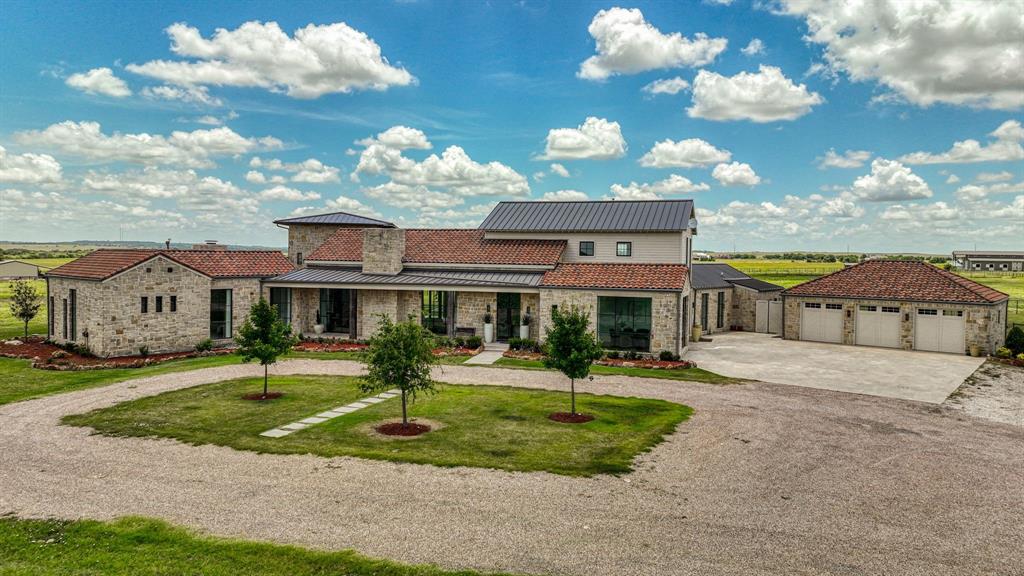 a front view of a house with a yard and potted plants