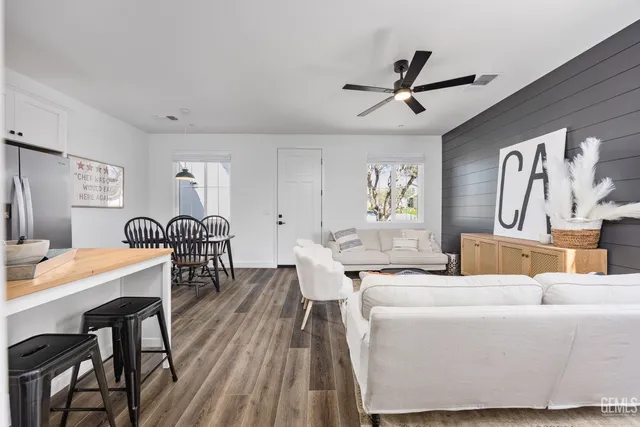 a living room with furniture a window and wooden floor