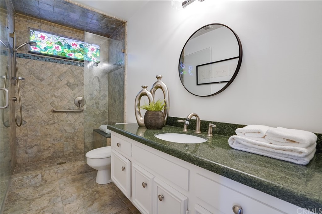 1988 Timberlane Way San Mateo, CA 94402 - Photo 9 of 36 a bathroom with a granite countertop toilet a sink and a mirror