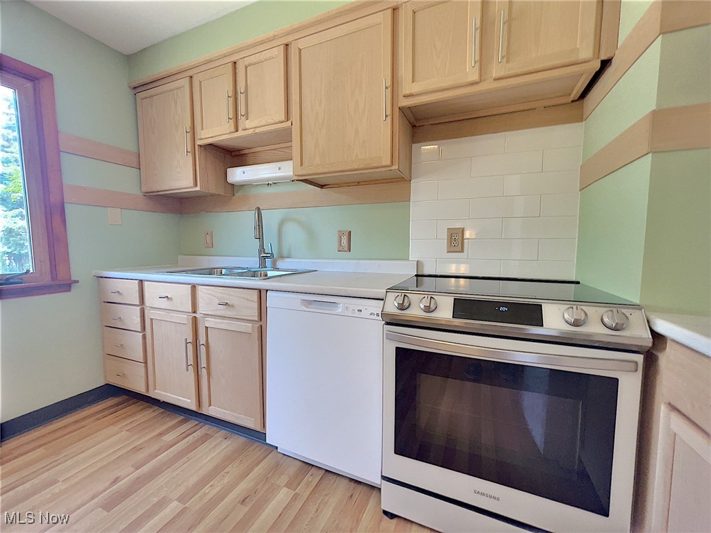 24000 Knickerbocker Road Bay Village, OH 44140 - Photo 7 of 27 Kitchen featuring electric stove, white dishwasher, sink, and light brown cabinets