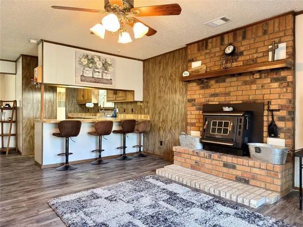 a kitchen with granite countertop a sink stainless steel appliances wooden floor and a counter top space