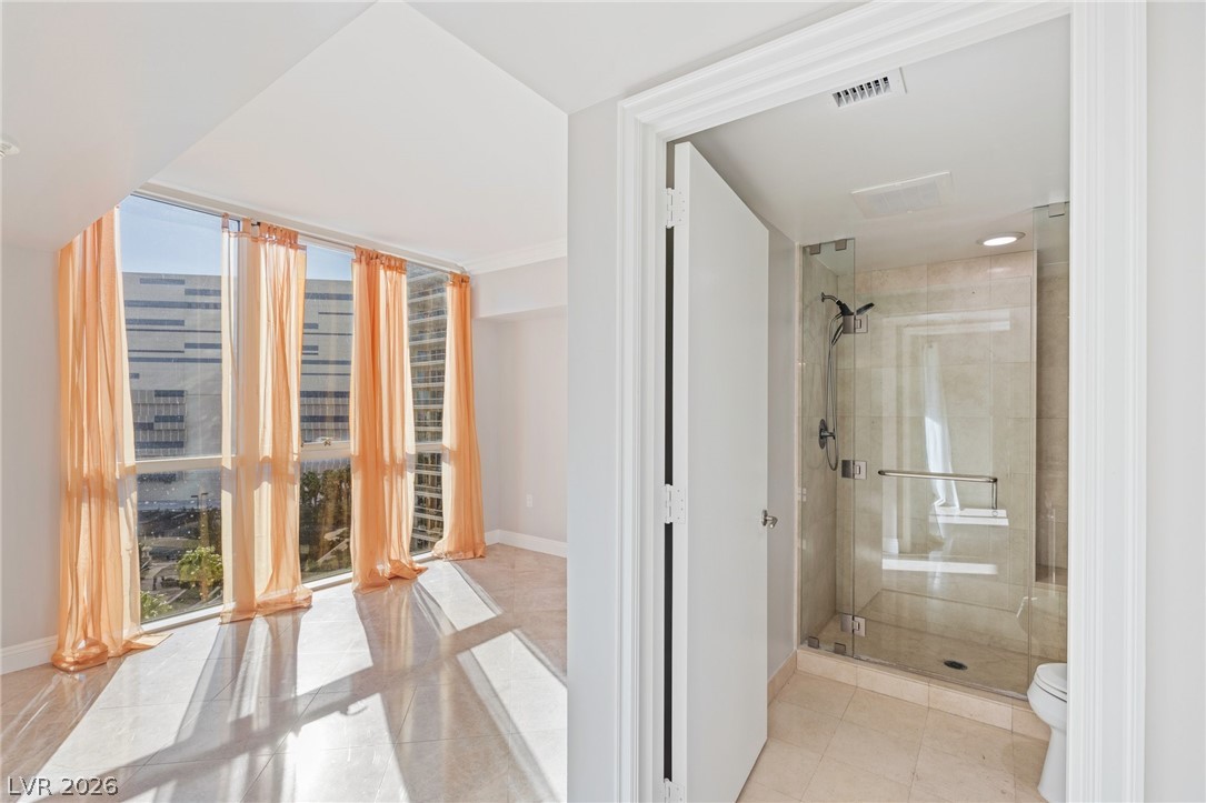 2777 Paradise Road, Unit 901 Las Vegas, NV 89109 - Photo 18 of 27 Bathroom featuring baseboards, visible vents, toilet, and a shower stall