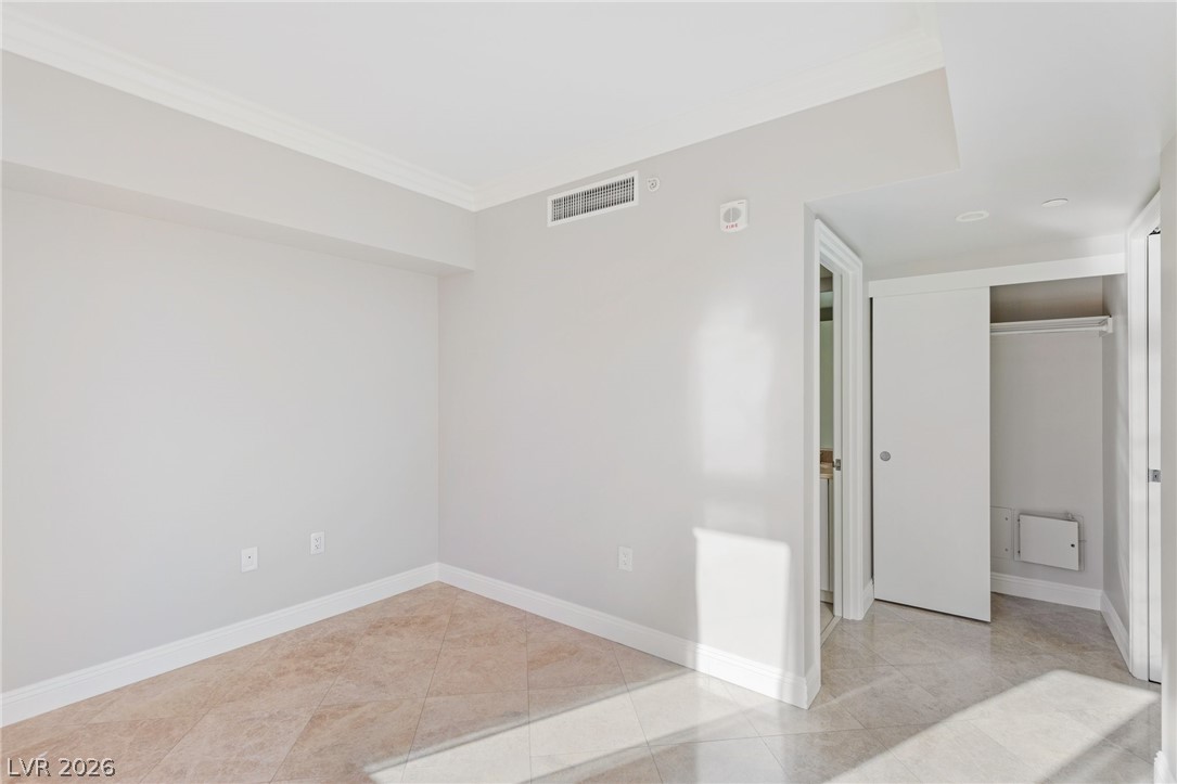 2777 Paradise Road, Unit 901 Las Vegas, NV 89109 - Photo 21 of 27 Unfurnished room with tile patterned floors, crown molding, baseboards, and visible vents