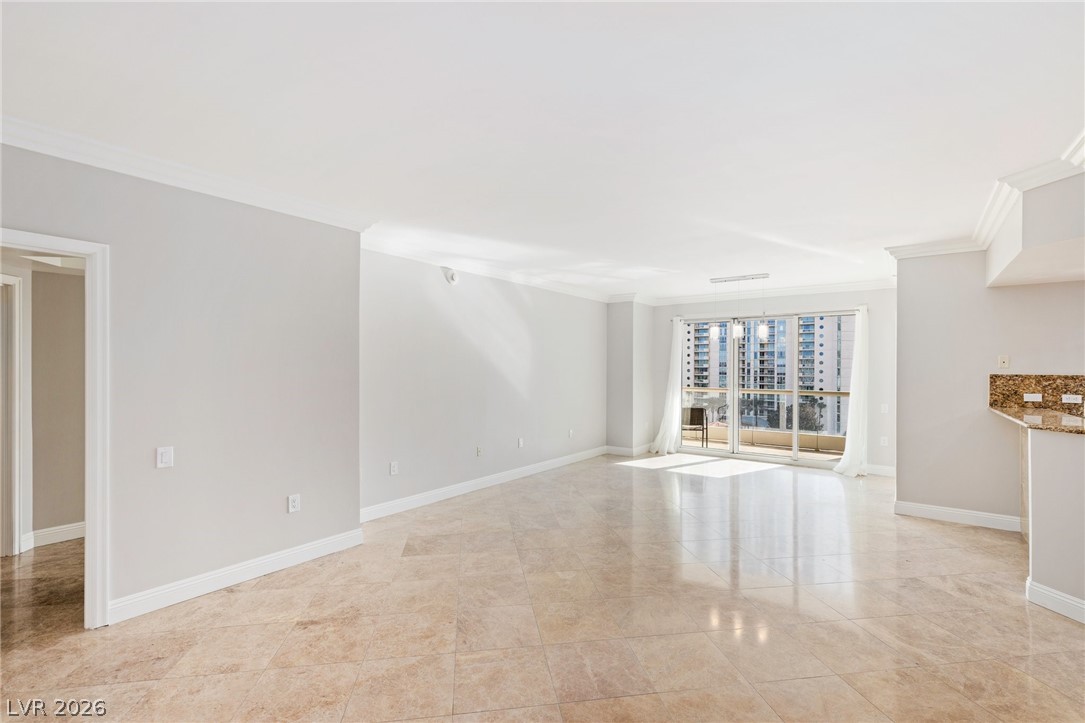 2777 Paradise Road, Unit 901 Las Vegas, NV 89109 - Photo 3 of 27 Unfurnished living room with baseboards, visible vents, and ornamental molding
