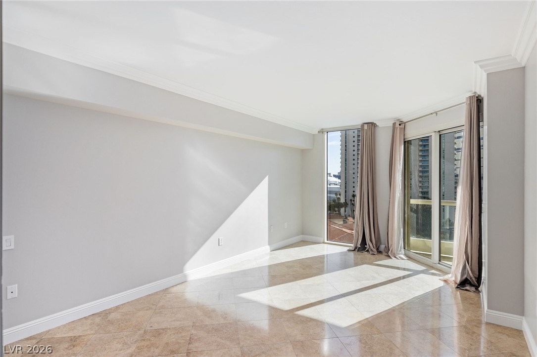 2777 Paradise Road, Unit 901 Las Vegas, NV 89109 - Photo 9 of 27 Empty room with baseboards, ornamental molding, and a wall of windows