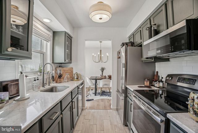 a kitchen with stainless steel appliances a stove microwave sink refrigerator and cabinets