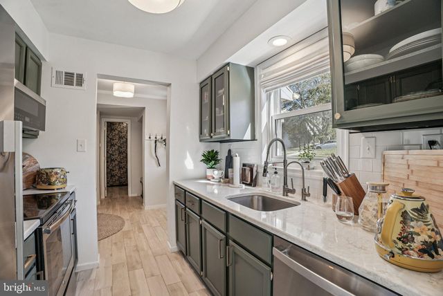a kitchen with stainless steel appliances granite countertop a sink stove and cabinets