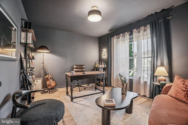 a living room with furniture gym equipment and a large window