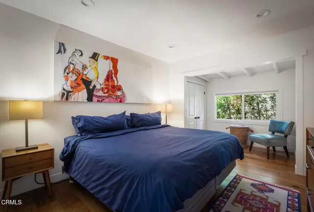 a bedroom with a bed and a painting on the wall