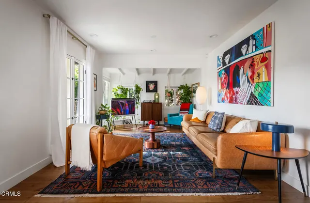 a living room with furniture a rug and a wall painting