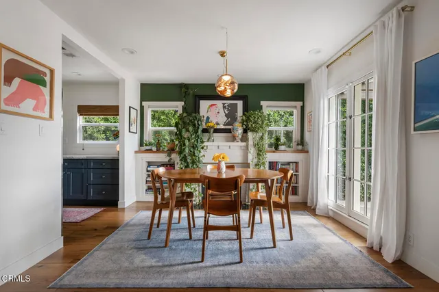 a dining room with wooden floor a chandelier a wooden table and chairs