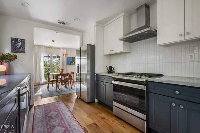 a kitchen with stainless steel appliances granite countertop a stove a sink and a refrigerator