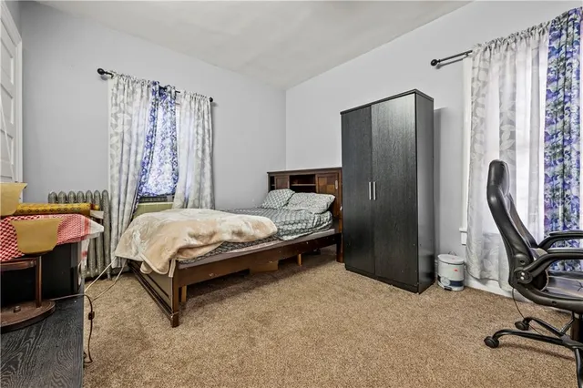 a bedroom with a bed chair and a desk