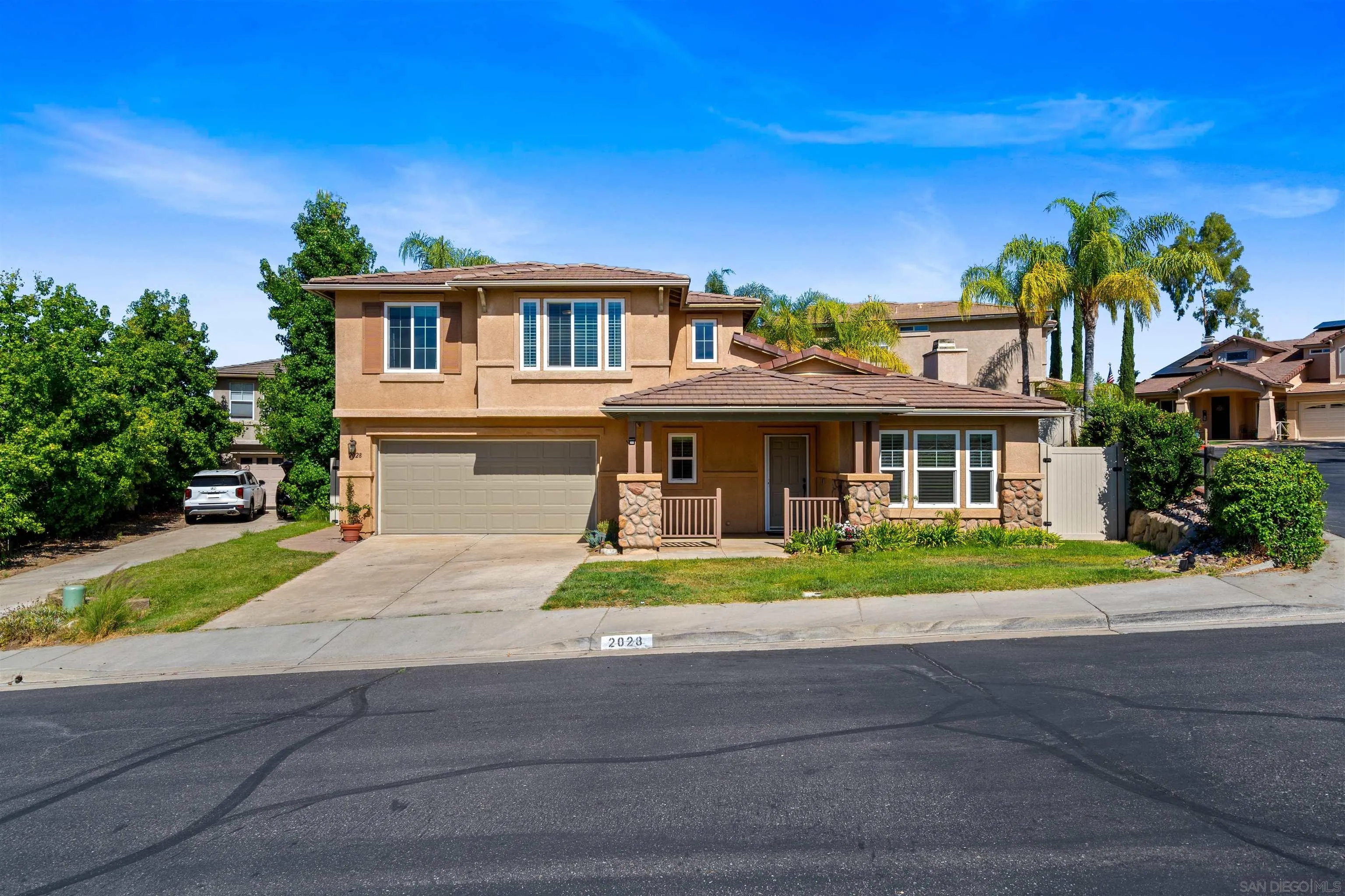 a front view of a house with a yard and potted plants