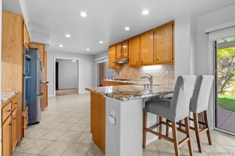 a kitchen with stainless steel appliances granite countertop a sink and a refrigerator