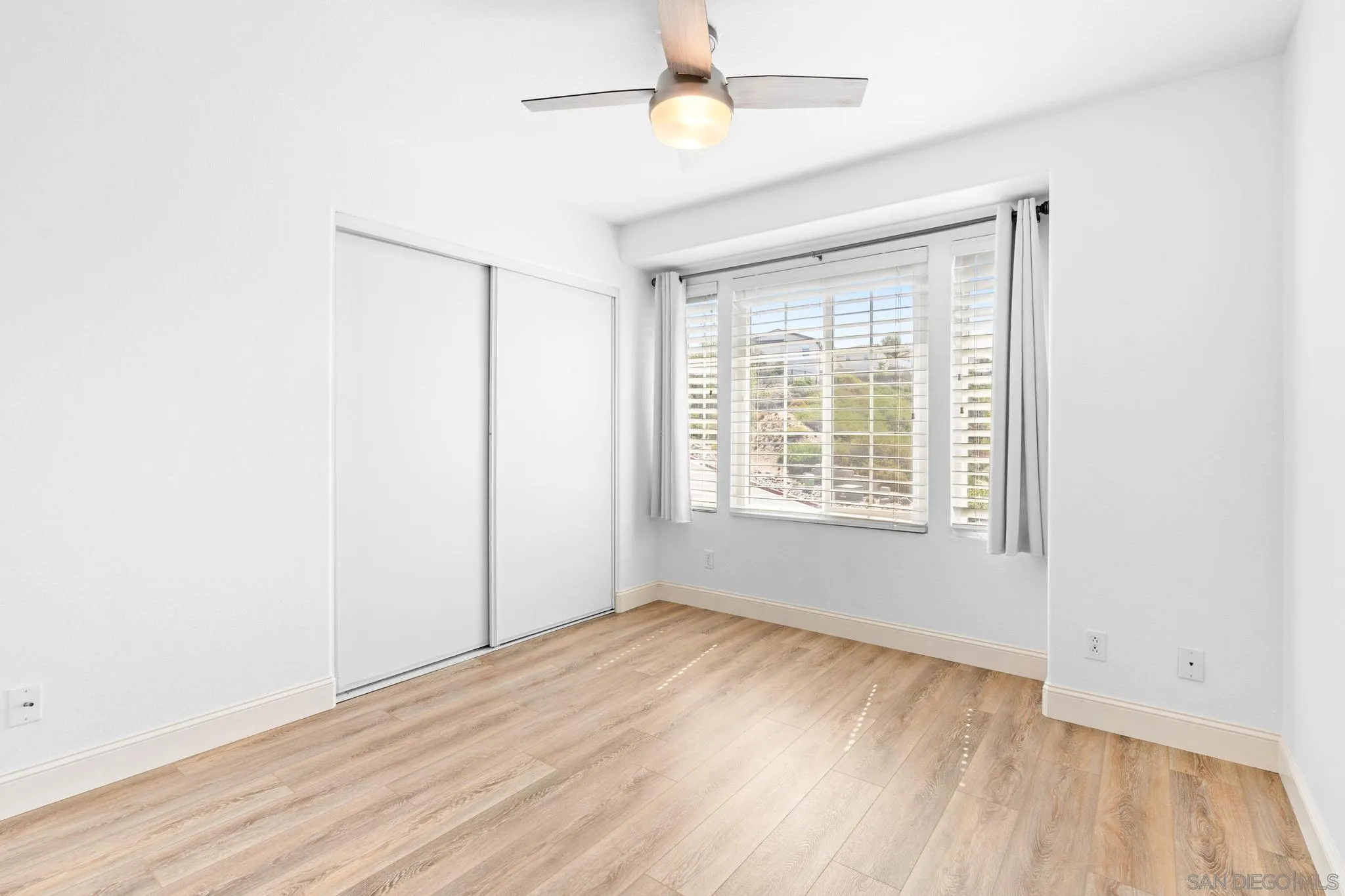 2028 Boulders Road Alpine, CA 91901 - Photo 36 of 56 a view of an empty room with wooden floor and a window