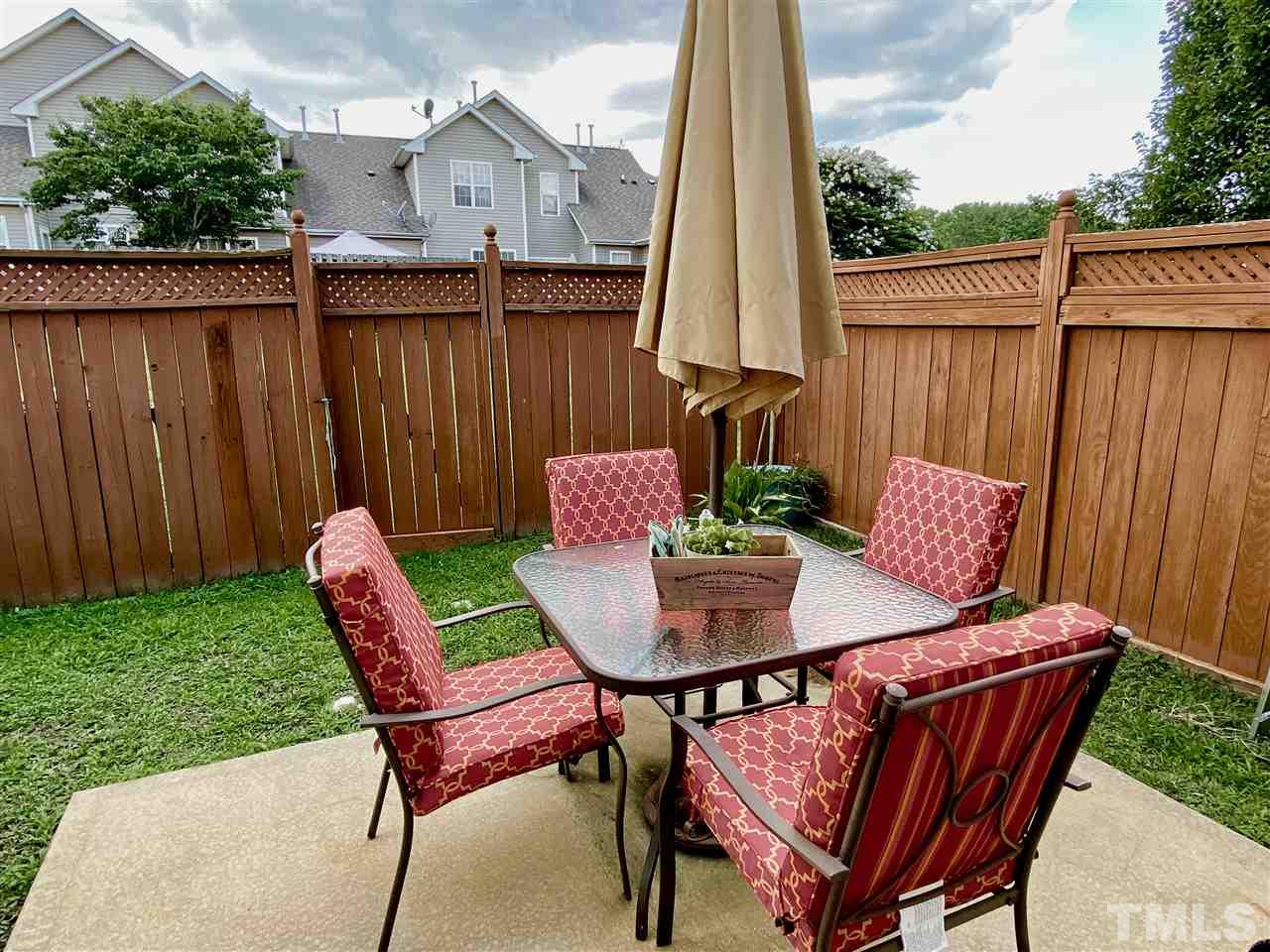 2746 Andover Glen Road Raleigh, NC 27604 - Photo 24 of 30 a view of a patio with table and chairs with wooden floor fence and a yard