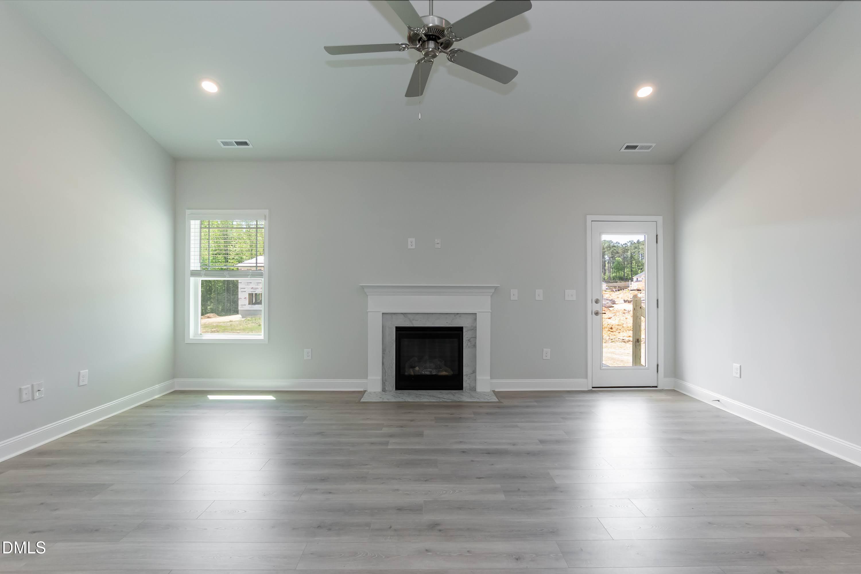1 Galway Road Lillington, NC 27546 - Photo 6 of 30 an empty room with wooden floor a fireplace and windows