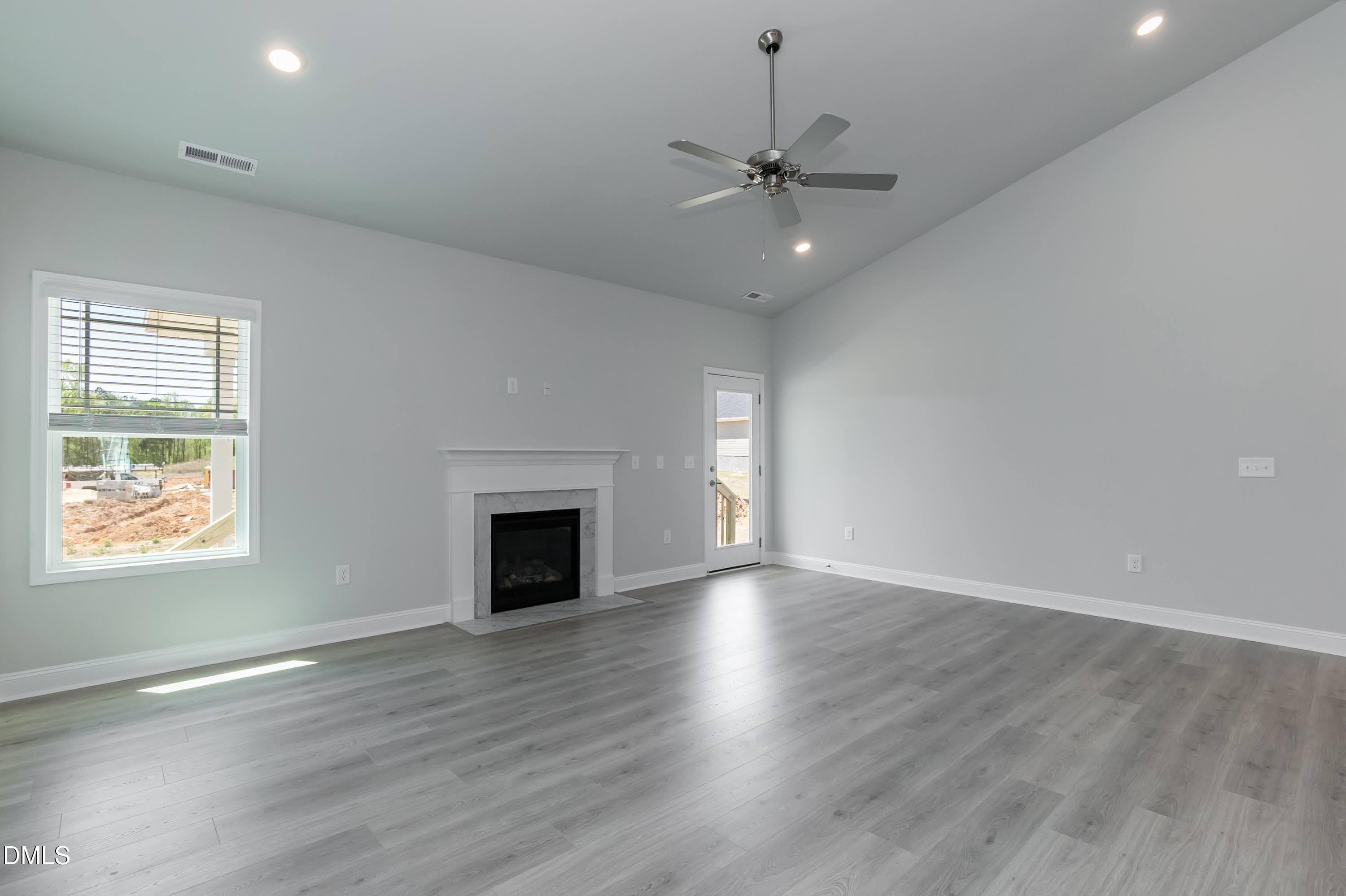 1 Galway Road Lillington, NC 27546 - Photo 7 of 30 an empty room with wooden floor fireplace and windows