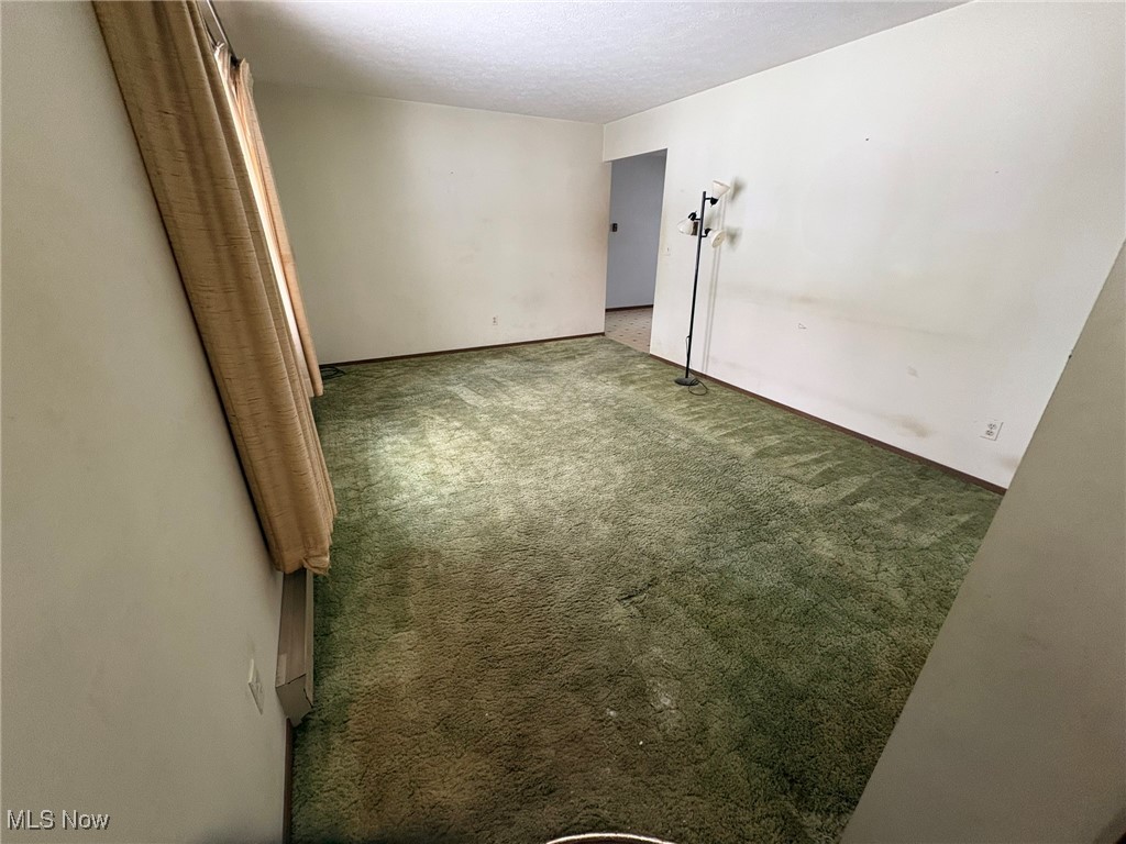 Carpeted spare room featuring a textured ceiling