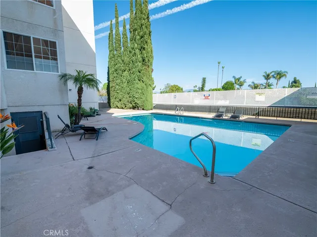 an empty room with windows and ceiling fan