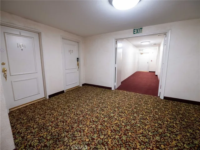 a view of a livingroom with wooden floor and a refrigerator