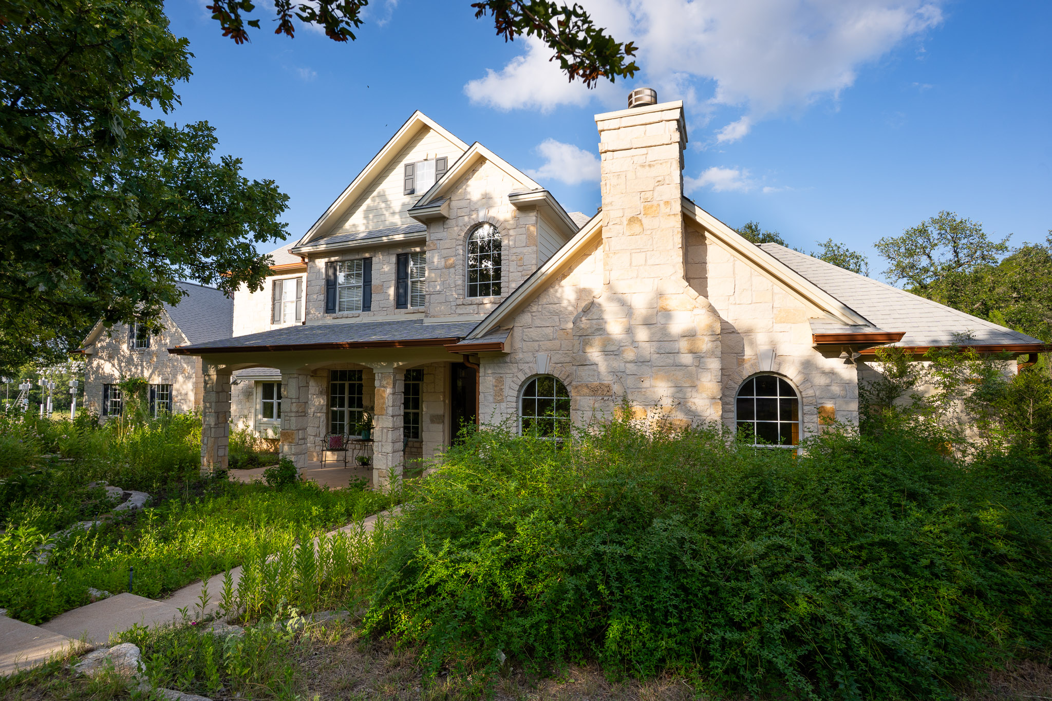 13800 Lone Rider Trail Austin, TX 78738 - Photo 2 of 32 An inviting stone facade with multiple arched windows creates a charming curb appeal.