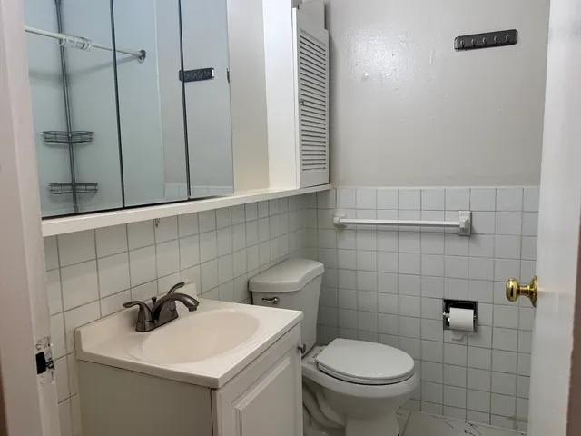 a bathroom with a toilet sink and mirror