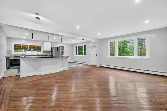 a view of a kitchen with kitchen island a counter top space a sink stainless steel appliances and cabinets