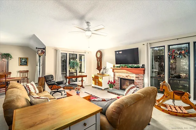 a living room with furniture a flat screen tv and a floor to ceiling window